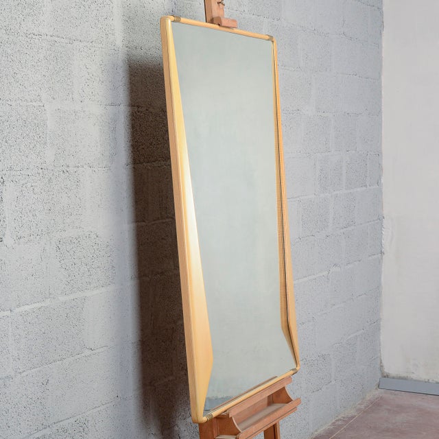 This elegant vintage mirror represents a refined example of mid-twentieth-century modernism and interior design by...