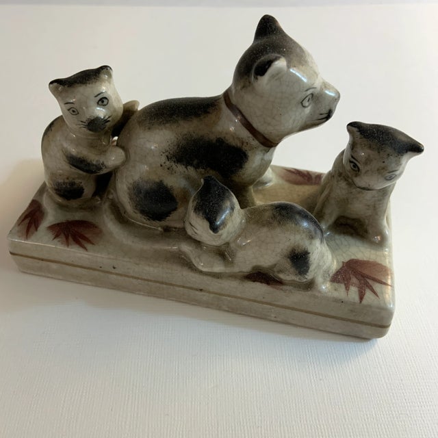 Vintage glazed ceramic family of mother cat with three kittens. Charming playful representation with decorative leaves...