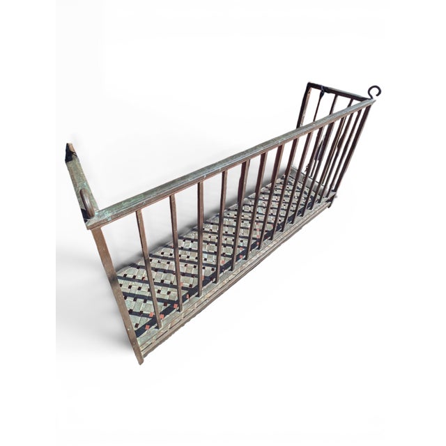 Reclaimed forged bronze balcony with woven bronze decking, square frame, and curled hanging hooks. It comes with bronze...