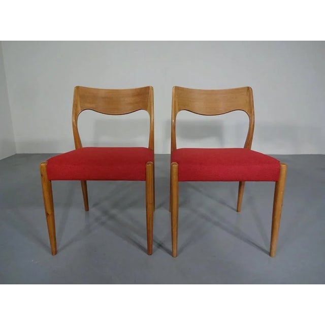 This set of two danish dining chairs are made from teak with a new upholstery in red fabric.