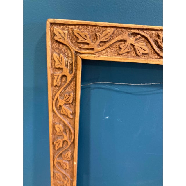 Hand crafted frame with vine motif. Well made and has wire hanger attached.