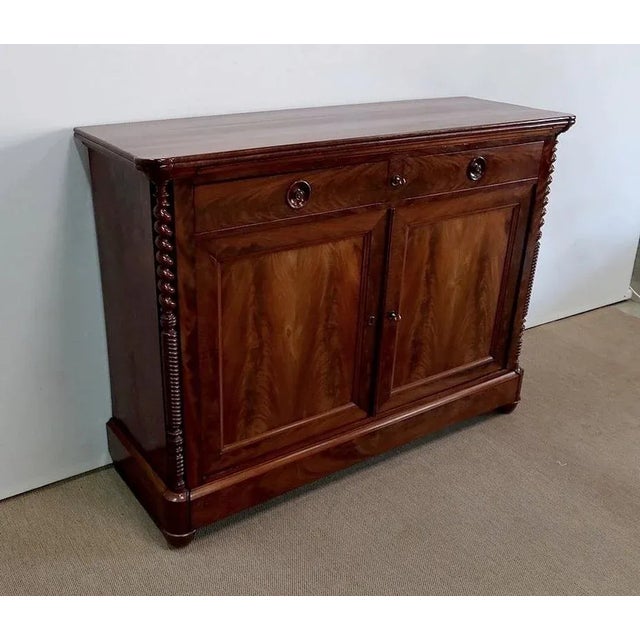 Mahogany sideboard designed in the early nineteenth century, consisting of a wooden top in mahogany burl veneer with a...