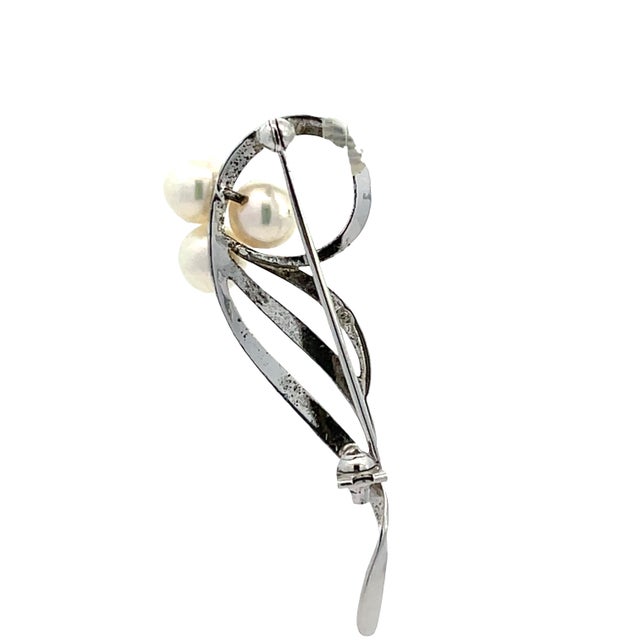 Elegant and refined, this Mikimoto brooch pin is crafted in sterling silver and features a graceful flowing design...