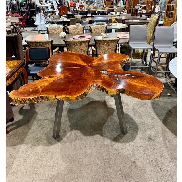 Striking live edge dining table featuring a naturally sculptural, free-form silhouette with flowing curves and an organic...