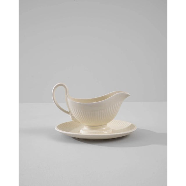 A vintage porcelain sauce boat made in Belgium, circa 1900. White china is finished with a luscious glossy glaze,...