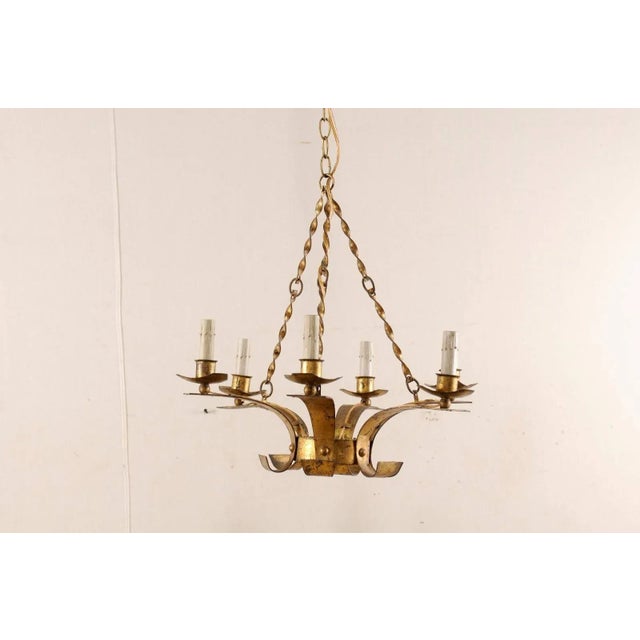 A French mid-20th century six-light chandelier. This French chandelier has a modern design featuring a small circular...