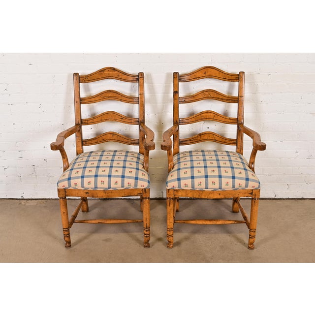 An exceptional pair of English Country or Rustic European style ladder back armchairs or dining captain chairs By Guy...
