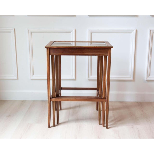 A refined set of three French nesting tables crafted in mahogany during the mid-twentieth century. Elegant in both...