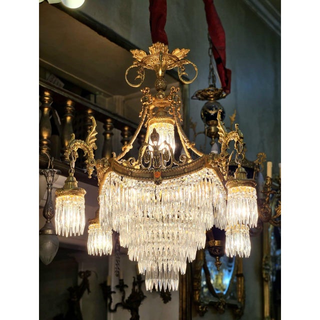 Illuminate your space with extraordinary elegance through this grand French Empire-style crystal chandelier, a...
