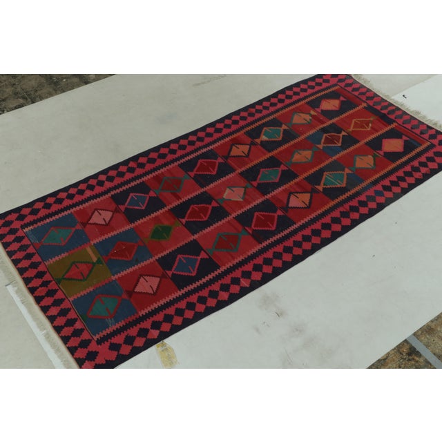 Hand-knotted in wool, an antique Persian Kilim rug originating circa 1920-1930, joining Rug & Kilim’s most coveted flat...