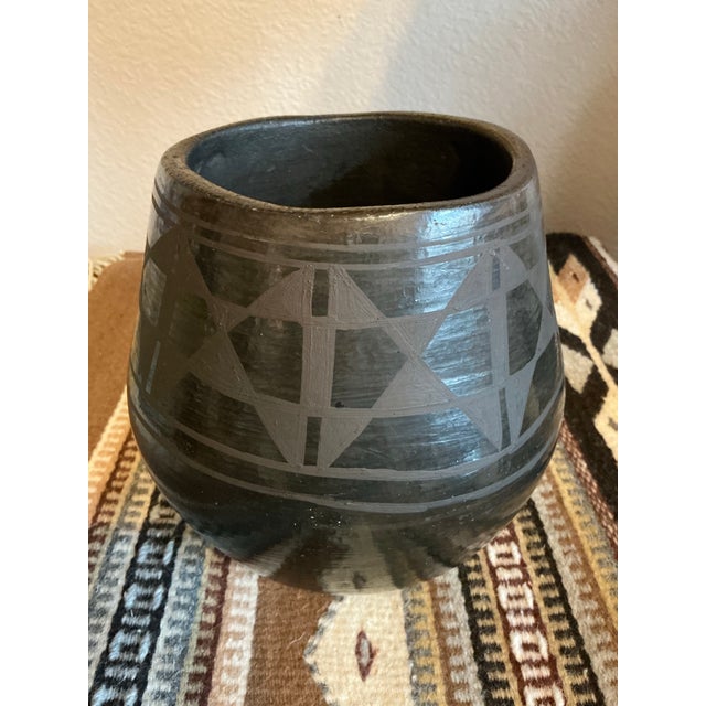 This collectible blackware pottery vessel by Vidal Aguilar (Santo Domingo Pueblo / Kewa Pueblo) features a beautifully...