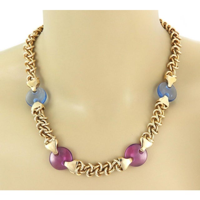 This vintage charm necklace features a pink and blue translucent acrylic button accented with 14k yellow gold. The woven...