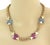 This vintage charm necklace features a pink and blue translucent acrylic button accented with 14k yellow gold. The woven...