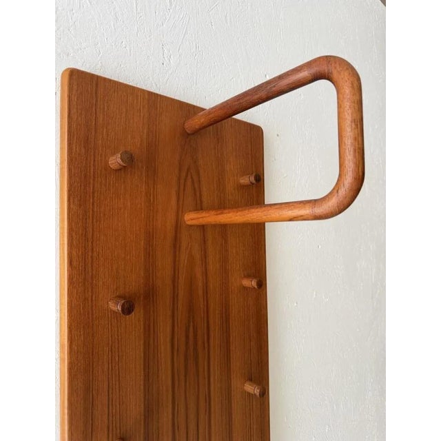 Three slender elements side by side, crafted from the same warm teak. It is precisely as a complete composition that this...