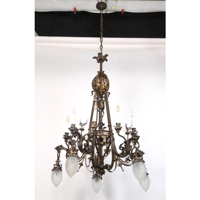 Neo Rococo style cast bronze chandelier with scrollwork along the arms, griffins on the end of the arms, and a salamander...