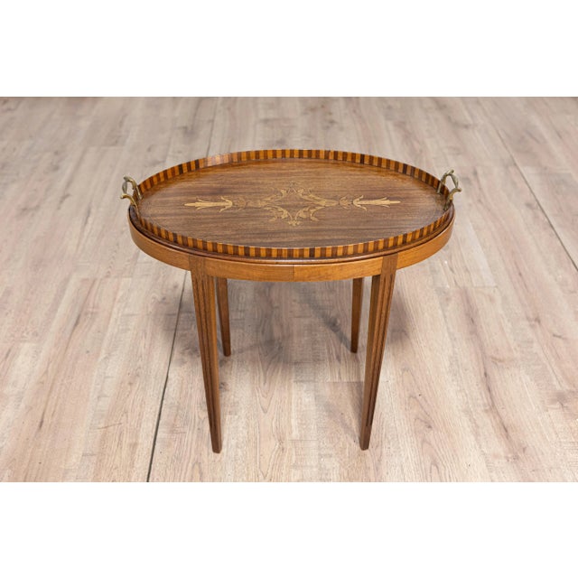A Danish walnut and ash tray top table from circa 1900 with foliage themed marquetry and tapered legs. This Danish walnut...