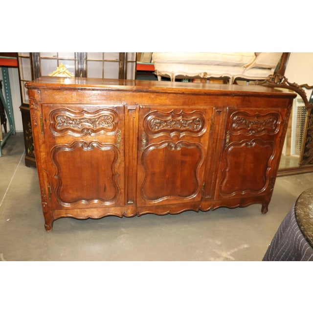 This is a gorgeous French country carved walnut sideboard with hand-hewn backboards and tons of character and age. The...
