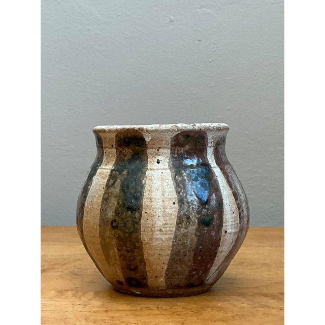 This vintage studio pottery vase is a compelling exploration of organic form and rhythmic surface decoration. Hand-thrown...