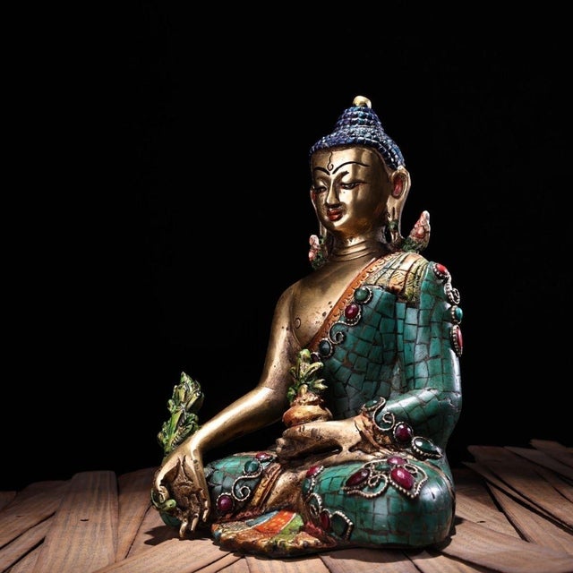 This finely crafted Medicine Buddha statue is cast from bronze with a gilt finish and decorated with extensive turquoise-...