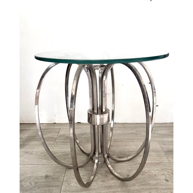 This eye-catching piece is a vintage Mid-Century Modern "Spider" or loop-ring table featuring a sculptural chrome base and...