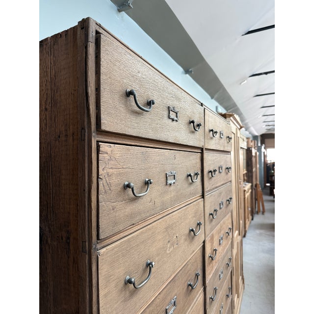 This large antique workshop cabinet, dating from the first half of the 20th century, impresses with its dimensions and its...