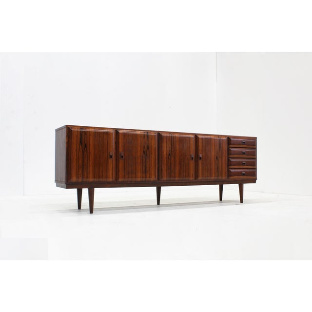 Vintage Mid Century sideboard designed in the 1960s made of teak and rosewood veneer with curved doors and solid wooden...