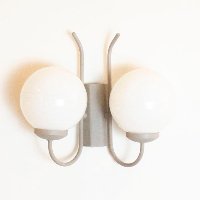 Vintage wall lamp with two light sources from the 1970s. 2 white opaline glass globes and metal structure in warm beige....