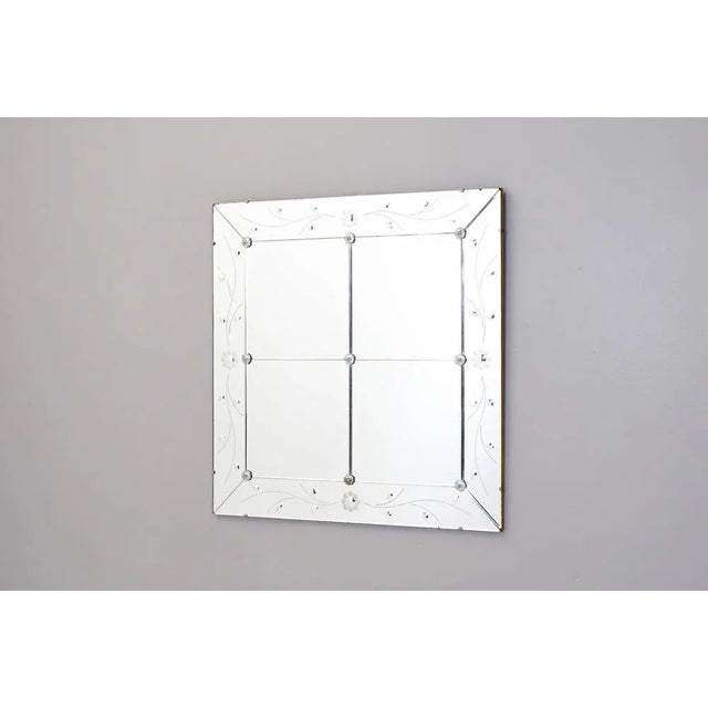 Frameless Venetian style mirror with floral details.