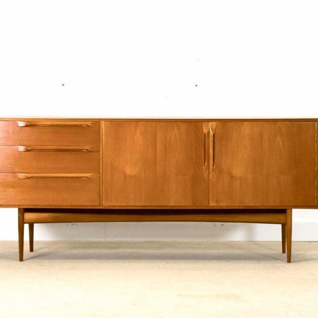 Designed by Tom Robertson for A.H. McIntosh in Scotland in the 1970s , this exquisite sideboard belongs to the prestigious...