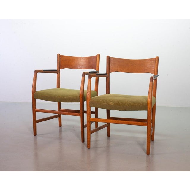 Sophisticated set of two Danish wooden armchairs with integrated black wooden arm rests by Hans Wegner for Plan Mobler....
