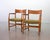 Sophisticated set of two Danish wooden armchairs with integrated black wooden arm rests by Hans Wegner for Plan Mobler....