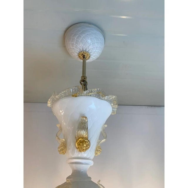 Classical milky and gold-leaf Murano glass chandelier with flowers and leaves. Traditional piece of italian art of blowing...