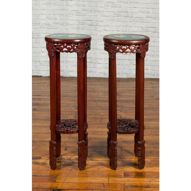 A pair of antique Chinese stands from the early 20th century, with painted floral and bird decor and carved aprons....