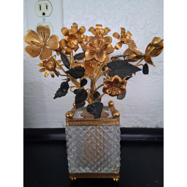 patinated bronze floral topiary cachepot featuring gleaming golden blossoms and dark patinated leaves. Bendable stems on...