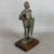 A striking and massive tabletop sculpture depicting a medieval knight in full armor with a sword and crossed shield,...