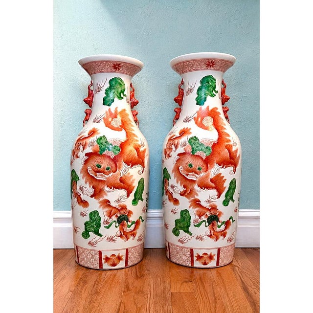 Pair of vintage Chinese porcelain baluster-form vases featuring vibrant hand-painted Foo Dog (Imperial Guardian Lion)...