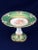 Antique French hand painted porcelain compote with cherubs, green border and gilt rim on scalloped column with a green...