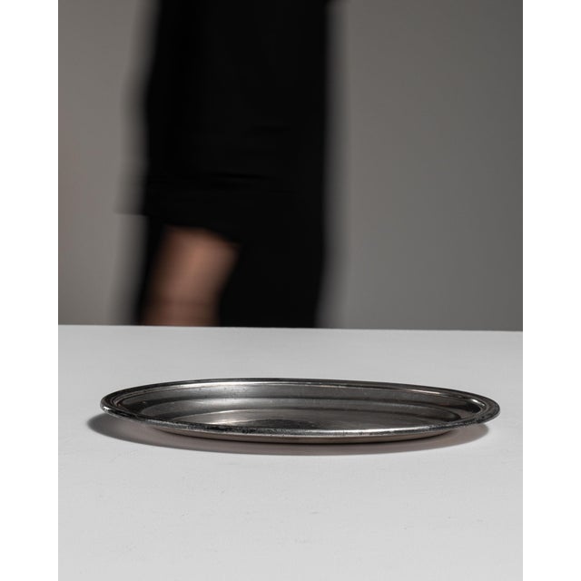 This early 20th century plate from France is finished in silver. Its form follows honest, well-proportioned lines typical...