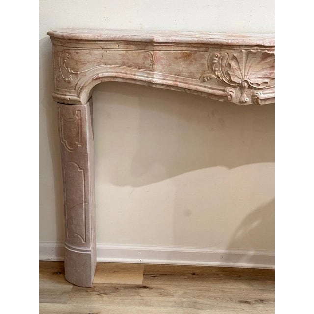 Fine French Marble Mantelpiece, 18th Century. Carved in pink and buff colored marble with a honed finish, the serpentine...