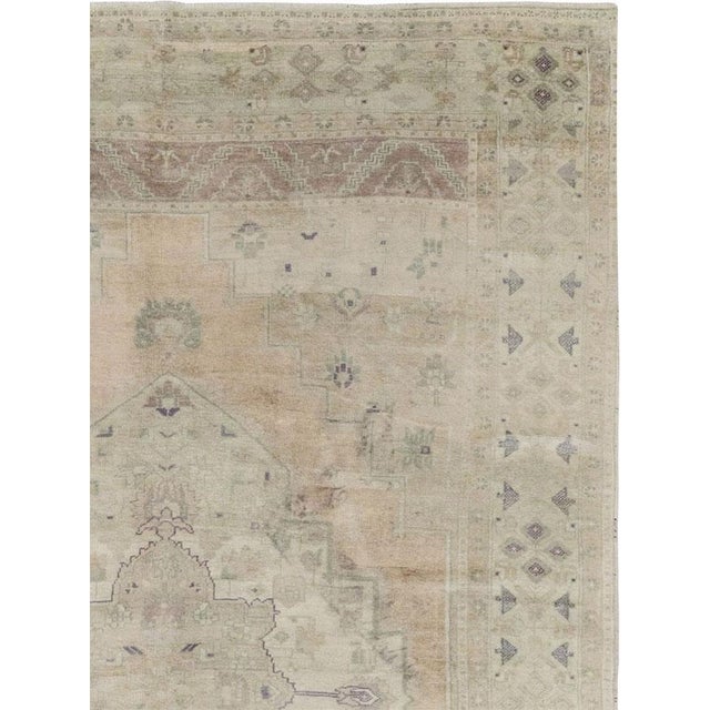 This Mid-20th century Turkish Anatolian accent carpet presents a softly geometric composition centered by a large, stepped...