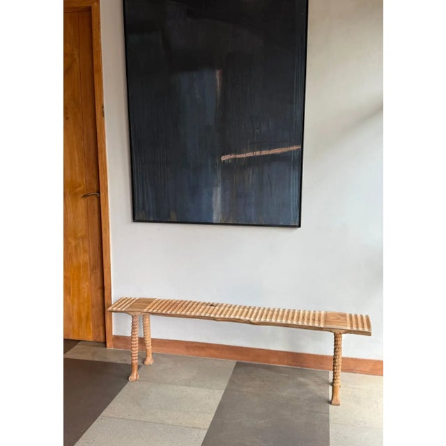 A sculptural teak bench showcasing the beauty of natural timber and traditional hand-carving. Crafted from solid teak, the...