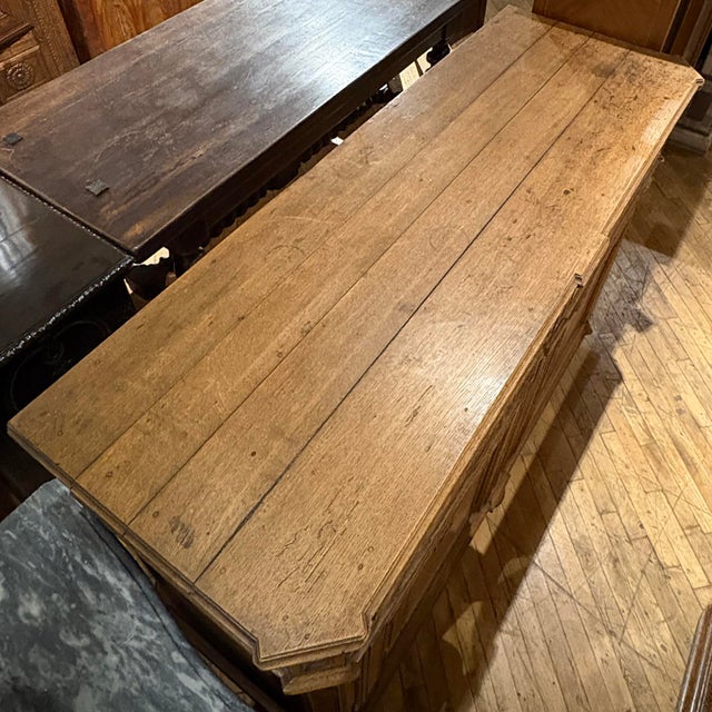 A beautifully crafted 18th-century French carved oak buffet featuring two drawers over a pair of paneled doors. The façade...
