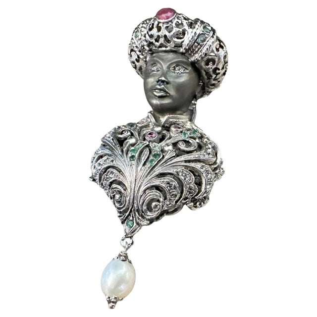 This is an exquisite 1990s Italian brooch crafted from sterling silver, accented with precious stones, showcasing...