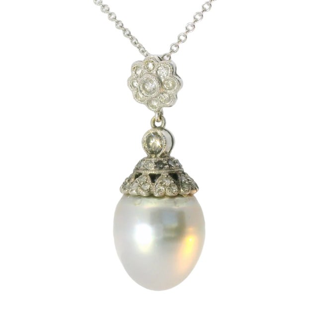 Elegant Estate 18K White Gold Filigree Pendant featuring a 12x”11 mm cultured white pearl surrounded by 44 sparkling...
