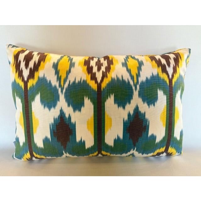 A stunning silk pillow from Les Ottomans featuring an embroidered floral motif on fine, rich blue silk on the front and...