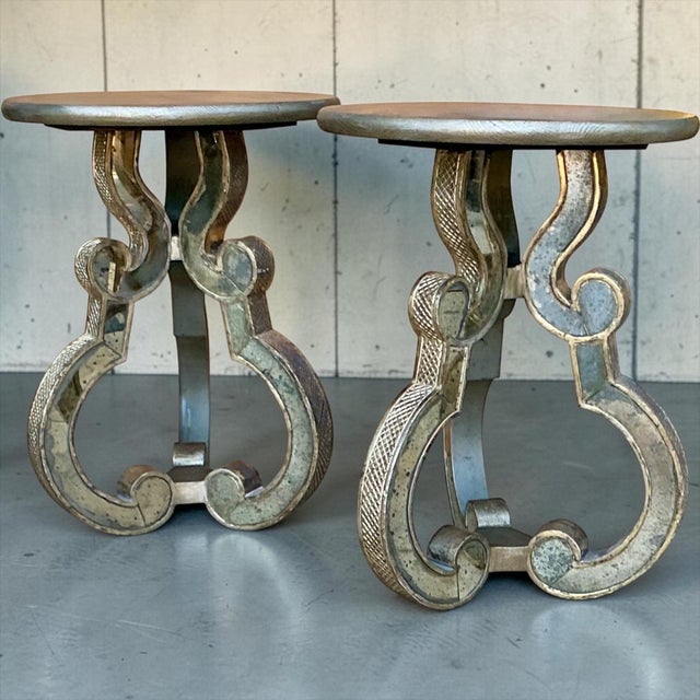This is a pair of Italian neoclassical style side tables by Palladio. The tops are silver gilt wood. The legs are carved...