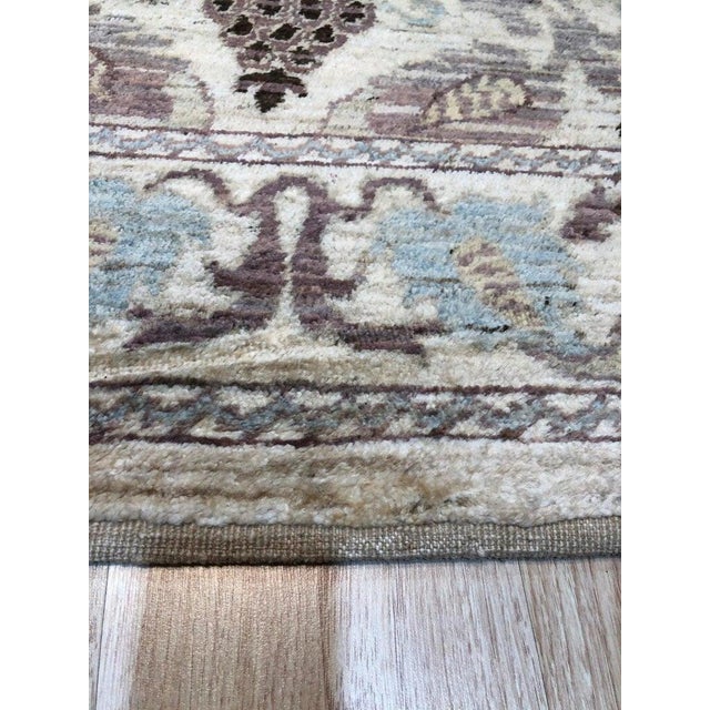 This hand knotted pile rug is crafted from wool and features a primary color palette of ivory, beige, cream, and white. It...