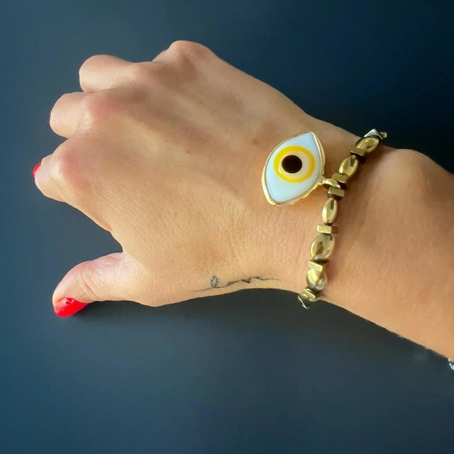 This Hematite Stone Yellow Evil Eye Charm Love Bracelet is a stunning piece of handmade jewelry that combines the timeless...