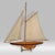 Offering a vintage pond yacht sailboat replica of a 1895 " Defender Cup Racer", circa Late 20th Century. It represents a...