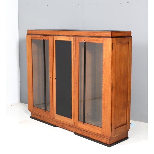 Stunning and rare Art Deco Modernist three-door bookcase. Striking Dutch design from the 1920s. Solid oak base with...